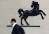 A man passes the entrance to a Lloyds Banking Group office in the City of London