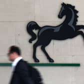 A man passes the entrance to a Lloyds Banking Group office in the City of London