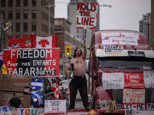 A demonstrator holds a placard during a protest by truck drivers over pandemic health rules and the Trudeau government, outside the parliament of Canada in Ottawa in February 2022