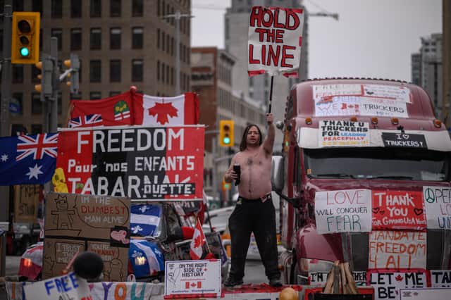 A demonstrator holds a placard during a protest by truck drivers over pandemic health rules and the Trudeau government, outside the parliament of Canada in Ottawa in February 2022