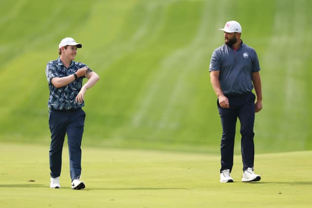 Bob MacIntyre chats with Jon Rahm during the Hero Dubai Desert Classic at Emirates Golf Club
