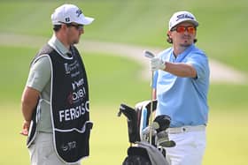 Ewen Ferguson ponders a club selection with caddie Stephen Neilson during the second round of the Hero Dubai Desert Classic