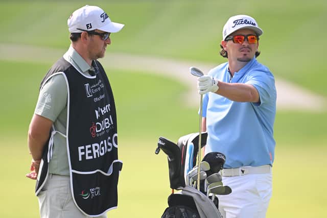 Ewen Ferguson ponders a club selection with caddie Stephen Neilson during the second round of the Hero Dubai Desert Classic