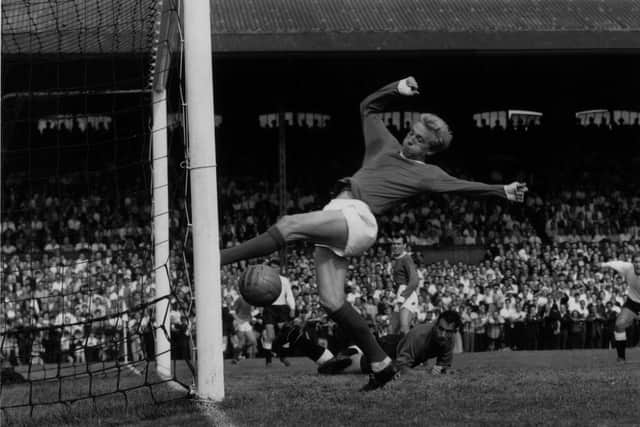 Scotland and Manchester United footballer Denis Law scoring during a game against Fulham.