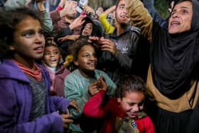 People celebrate along a street at Deir el-Balah in the central Gaza Strip,as news spread that a ceasefire and hostage release deal had been reached between Israel and Hamas.
