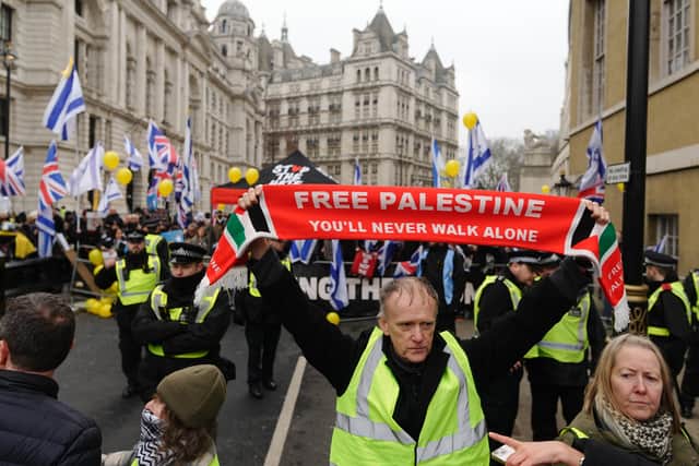 People take part in a national march for Palestine on Whitehall in central London.