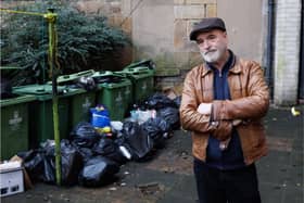 David Richardson next to the overflowing bins