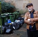 David Richardson next to the overflowing bins