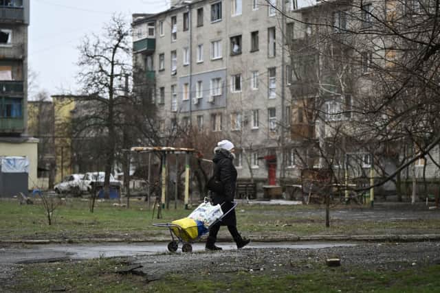 A local resident walks among damaged residential buildings in the town of Lyman, near the frontline in the Donetsk region of Ukraine.