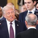 U.S. President Donald Trump takes the oath of office as Barron Trump and Melania Trump look on.