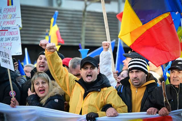 Supporters of nationalist party AUR (Alliance for the Union of Romanians) and of presidential candidate Calin Georgescu attend a march in Bucharest to protest against the annulment of the presidential election. (Photo by Daniel MIHAILESCU / AFP) (Photo by DANIEL MIHAILESCU/AFP via Getty Images)