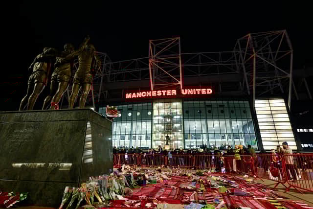 Tributes to former Manchester United legend Denis Law surround the statue which also features George Best and Sir Bobby Charlton statue outside Old Trafford stadium.