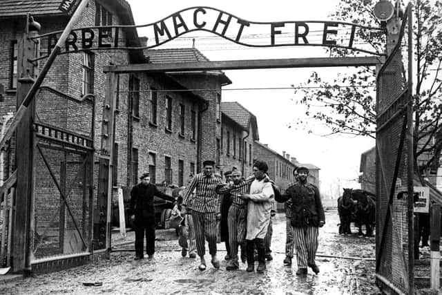 Survivors of the Nazi's Auschwitz-Birkenau camp are led through its infamous gate in 1945 following its liberation by Soviet troops (Picture: Wojtek Laski)