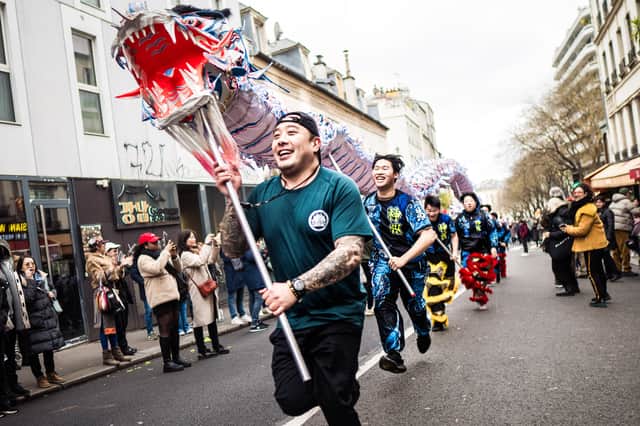 People hold a dragon during the Paris Belleville Chinese New Year parade in Paris, France.