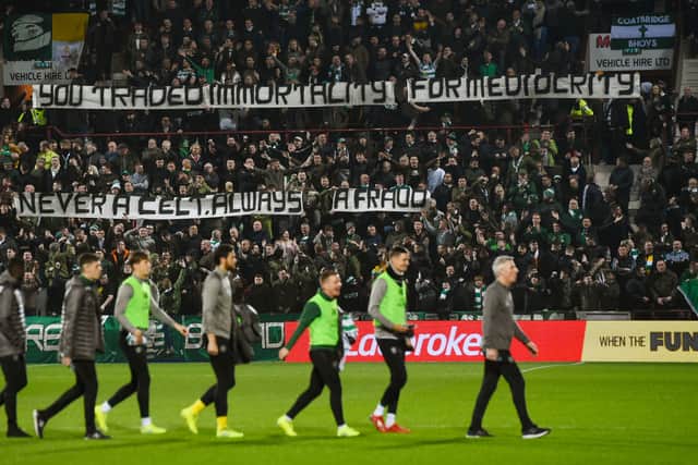 Celtic subs walk past a banner aimed at former manager Brendan Rodgers following his departure to Leicester in 2019.