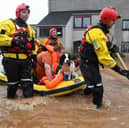 A couple and their dog are rescued from a flooded street in Brechin on October 20, 2023
