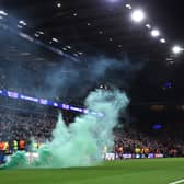 Stewards remove a green flare off the pitch during the Champions League match between Aston Villa and Celtic at Villa Park on January 29, 2025. (Photo by Julian Finney/Getty Images)