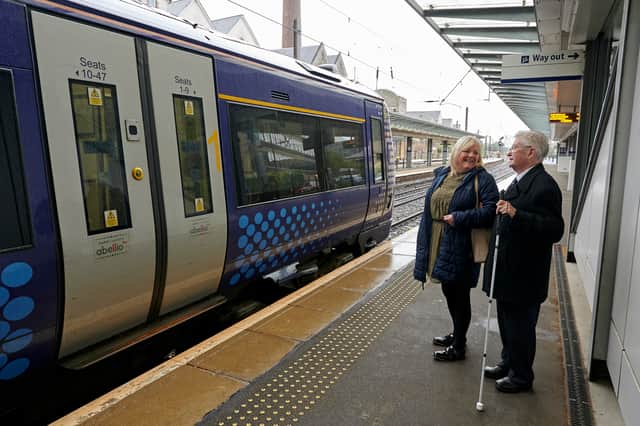 A companion assisting a person with sight loss at Haymarket Station in Edinburgh