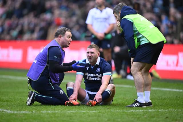 Finn Russell receives medical treatment following his collision with Scotland team-mate Darcy Graham.
