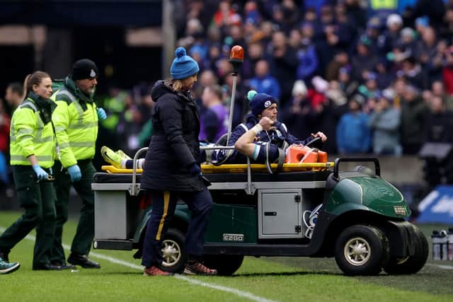 Scotland wing Darcy Graham gives a thumbs up gesture as he leaves the pitch on a medical buggy against Ireland.
