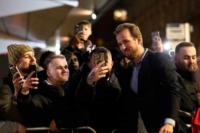Bayern Munich's Harry Kane arrives at the Glasgow team hotel and poses with some fans.