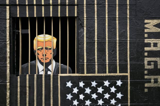A piece of street art in the Gorbals, Glasgow, by artist Ashley Rawson, showing US president Donald Trump behind bars (Picture: Jane Barlow)