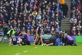 Scotland's Finn Russell, left, and Scotland's Darcy Graham, right, are treated following the clash of heads against Ireland.