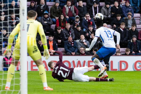 Hearts striker James Wilson falls under the challenge of Rangers defender Clinton Nsiala.