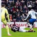 Hearts striker James Wilson falls under the challenge of Rangers defender Clinton Nsiala.