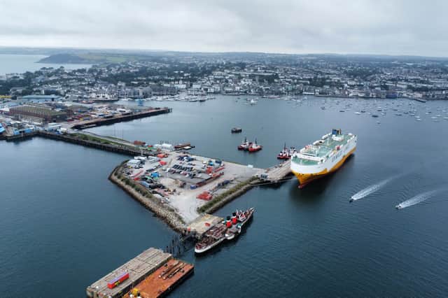 Waverley dwarfed beside a cargo vessel in Falmouth harbour in Cornwall in 2024