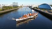 Waverley departing from its berth beside Glasgow Science Centre