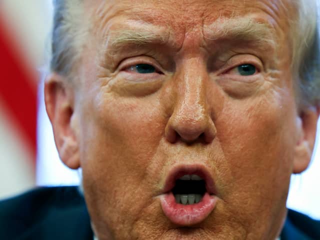 President Donald Trump speaks to reporters in the Oval Office at the White House in Washington
