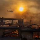 A firefighting helicopter flies over a wildfire as it burns homes in Camarillo, California in November (Picture: David McNew)