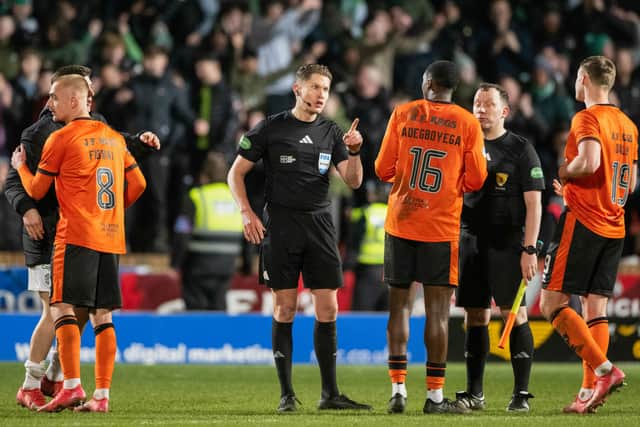 Referee David Dickinson speaks to Dundee United's Emmanuel Adegboyega during a controversial match against Hibs.