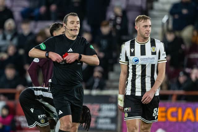 Referee Euan Anderson puts away his red card after overturning his decision to send off St Mirren's Killian Phillips for a challenge on Hearts' Jamie McCart. (Photo by Mark Scates / SNS Group)