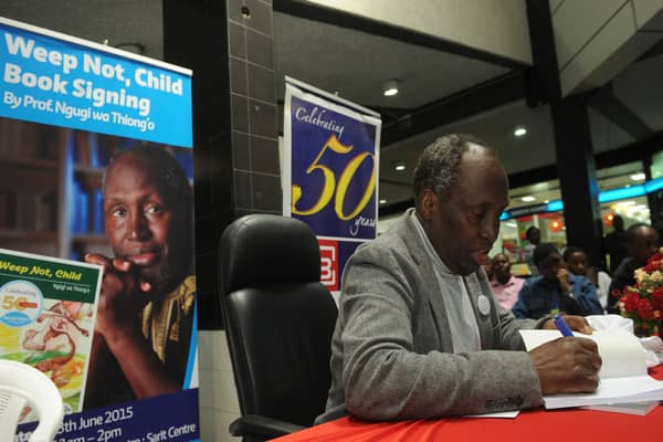 Ngugi wa Thiong'o signs a copy of one of his books for a fan during a celebration of the golden jubilee of his first book Weep Not Child in Nairobi in 2015. During his time in prison in the 1970s, he switched from writing in English to his native Gikuyu.
