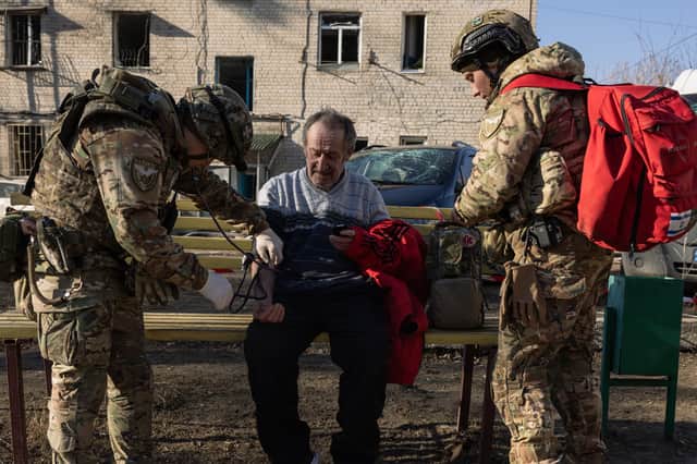 Ukrainian army medics provide first aid to a man at the scene of a Russian Iskander missile attack on a residential building in Kharkiv, Ukraine on Friday (Picture: Diego Fedele)