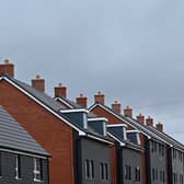 An electricity pylon is pictured beyond newly built residential properties at a construction site for new houses and homes near Aylesbury in July 2023 (Photo: JUSTIN TALLIS/AFP via Getty Images)
