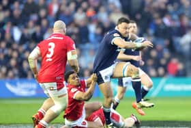Scotland's Jack Dempsey is tackled by Wales' Ben Thomas during the Guinness Six Nations match at Murrayfield.