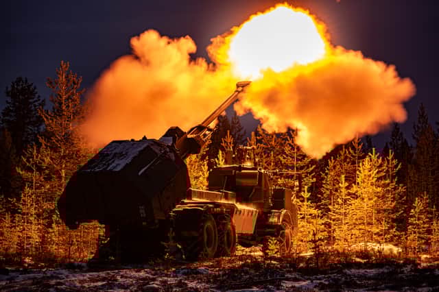 A muzzle flash lights up pine trees as the British Army's new Archer Mobile Howitzer gun fires, as British Army soldiers take part in training near Rovaniemi in the Arctic Circle, Finland, in November 2024.