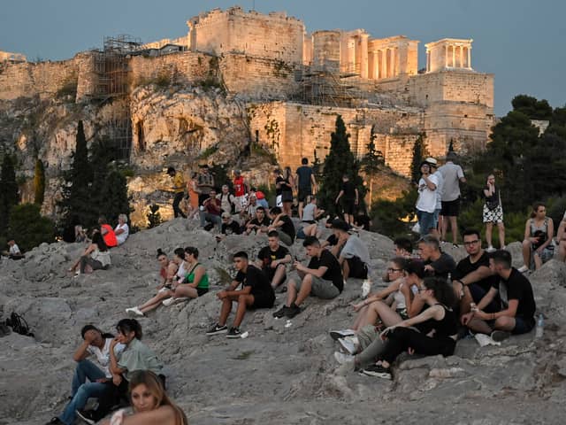 People sit on the Areopagus hill, where the ancient Athenians once held trials (Picture: Louisa Gouliamaki)
