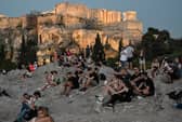 People sit on the Areopagus hill, where the ancient Athenians once held trials (Picture: Louisa Gouliamaki)