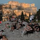 People sit on the Areopagus hill, where the ancient Athenians once held trials (Picture: Louisa Gouliamaki)