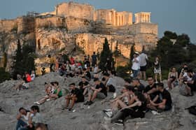 People sit on the Areopagus hill, where the ancient Athenians once held trials (Picture: Louisa Gouliamaki)