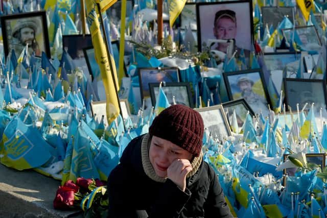 A woman sheds tears at a makeshift memorial for fallen soldiers in Kyiv's Independence Square on the third anniversary of Russia's full-scale invasion (Picture: Sergei Supinsky)