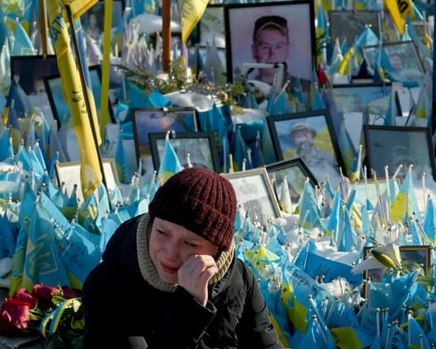 A woman sheds tears at a makeshift memorial for fallen soldiers in Kyiv's Independence Square on the third anniversary of Russia's full-scale invasion (Picture: Sergei Supinsky)