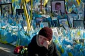A woman sheds tears at a makeshift memorial for fallen soldiers in Kyiv's Independence Square on the third anniversary of Russia's full-scale invasion (Picture: Sergei Supinsky)