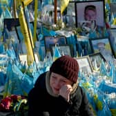A woman sheds tears at a makeshift memorial for fallen soldiers in Kyiv's Independence Square on the third anniversary of Russia's full-scale invasion (Picture: Sergei Supinsky)