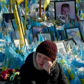 A woman sheds tears at a makeshift memorial for fallen soldiers in Kyiv's Independence Square on the third anniversary of Russia's full-scale invasion (Picture: Sergei Supinsky)