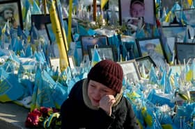 A woman sheds tears at a makeshift memorial for fallen soldiers in Kyiv's Independence Square on the third anniversary of Russia's full-scale invasion (Picture: Sergei Supinsky)